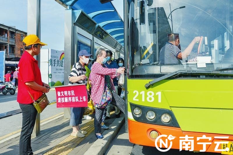 在衡阳路公交车站,市民在志愿者的引导下有序排队上车.记者黄维业摄